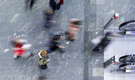 Woman standing in lobby with people walking (470x280)