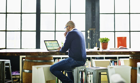 Man sitting at desk with laptop doing data analysis