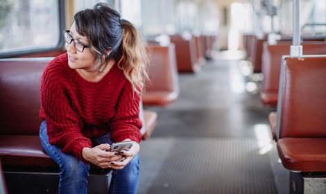 millennial woman using mobile phone on train