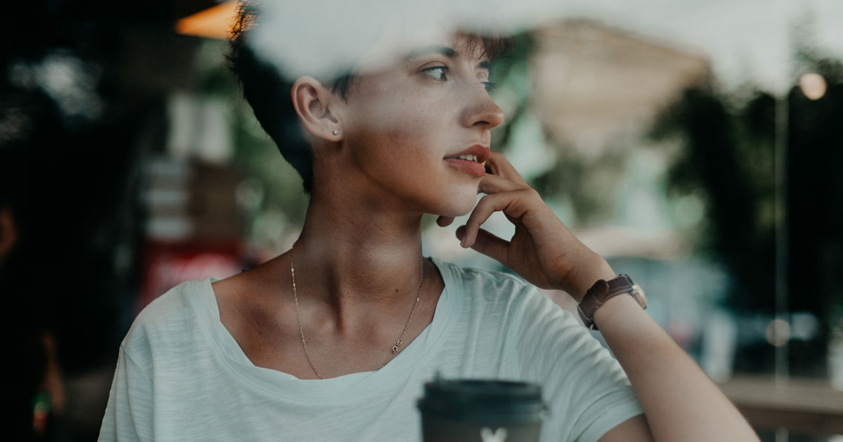 woman looking out window coffee shop